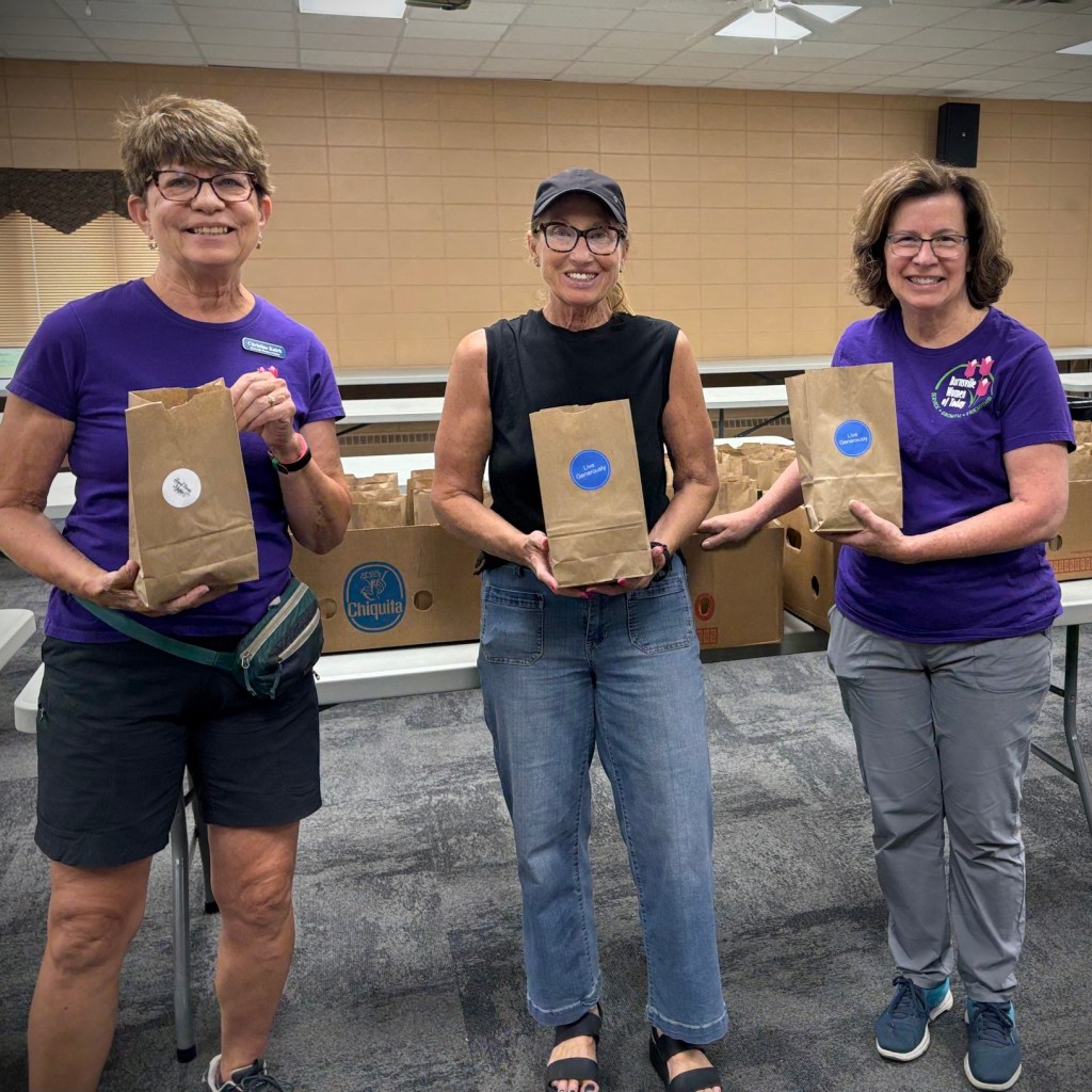 Three Burnsville Women of Today members volunteering service hours to feed local families